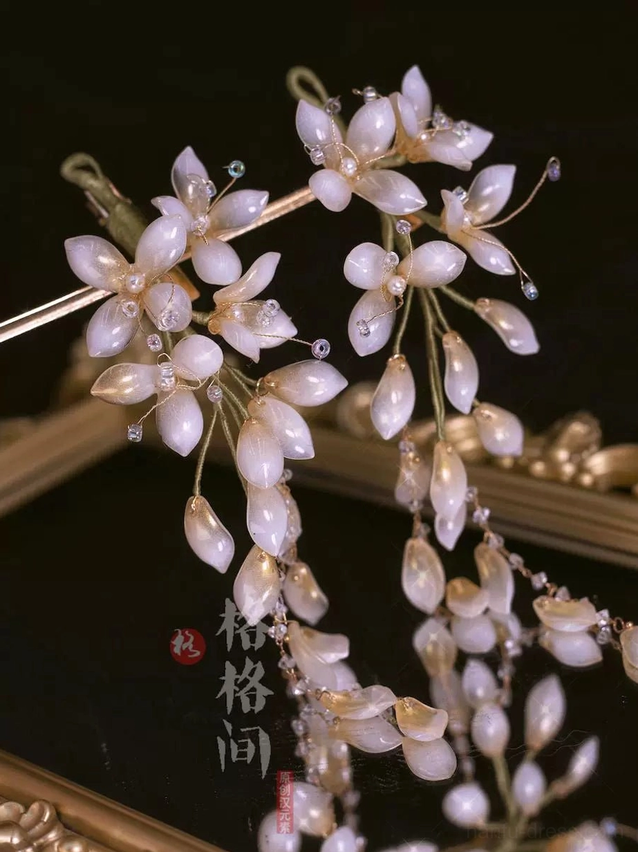 Champagne beige wisteria glass hair pins with warm neutral flower petals and delicate dangling bead branches on a gilded tray