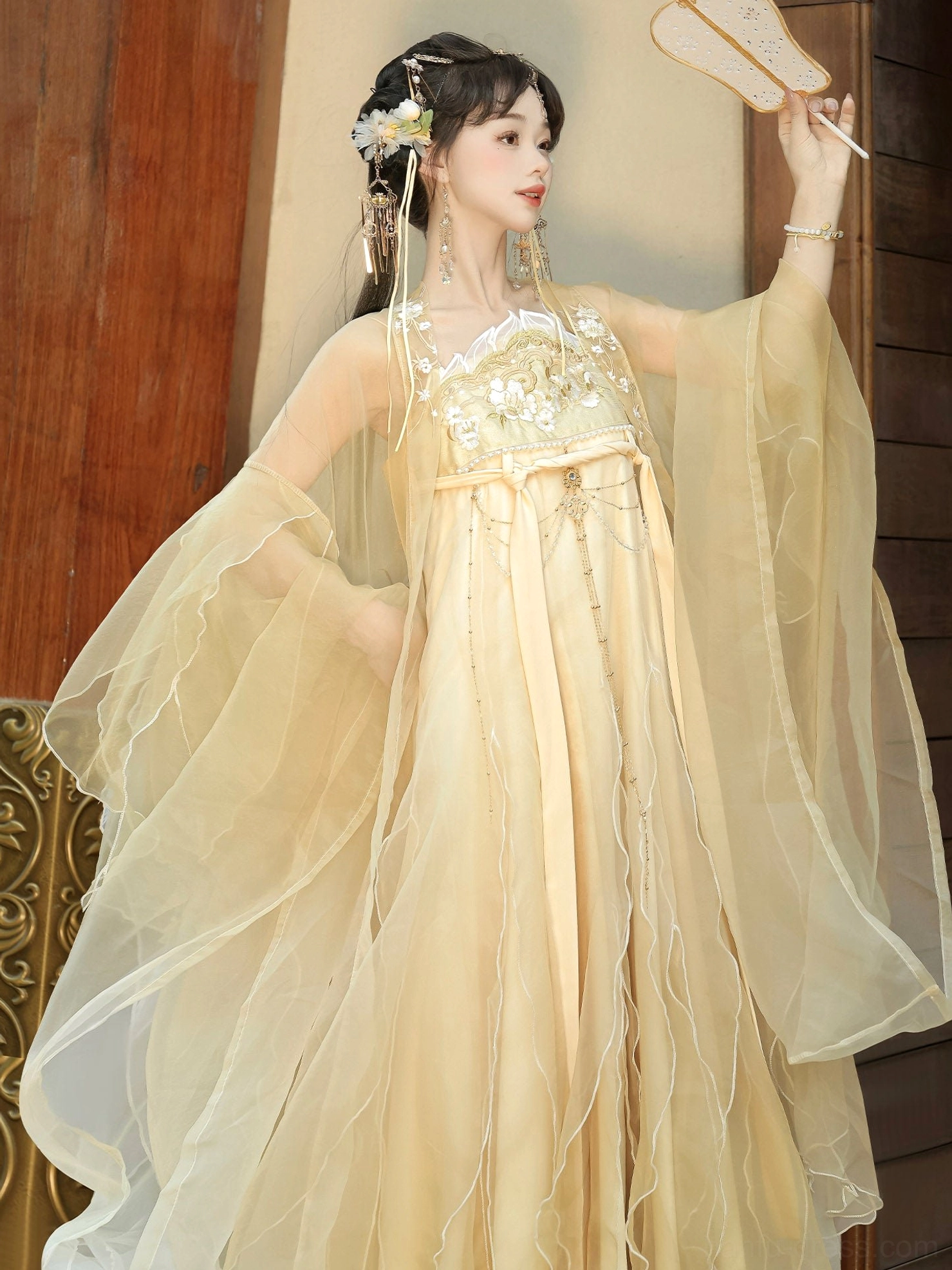 Champagne gold Qixiong Ruqun Tang Dynasty hanfu shown from the front with floral embroidered bodice, sheer ruffled wide sleeves, waist sash, decorative metal waist detail, and traditional silk fan