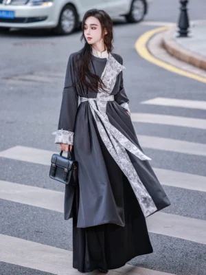 Female model wearing the solid charcoal gray side of a reversible Hanfu round collar robe with stand collar inner layer printed sash and contrast cuffs