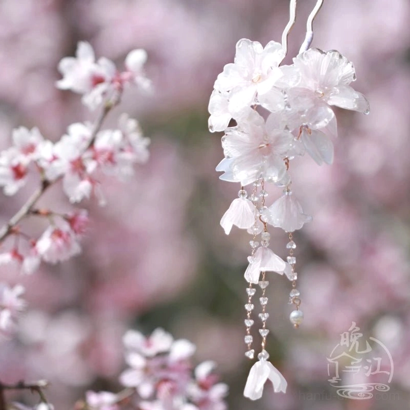 Side view of a cherry blossom Chinese hair stick with translucent pink flower clusters pearl pendants and elegant hanging metal tassels