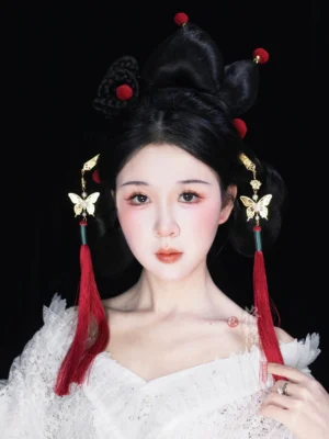 Woman wearing red Chinese butterfly tassel hair pins with gold-tone ornaments in a traditional Hanfu-inspired updo