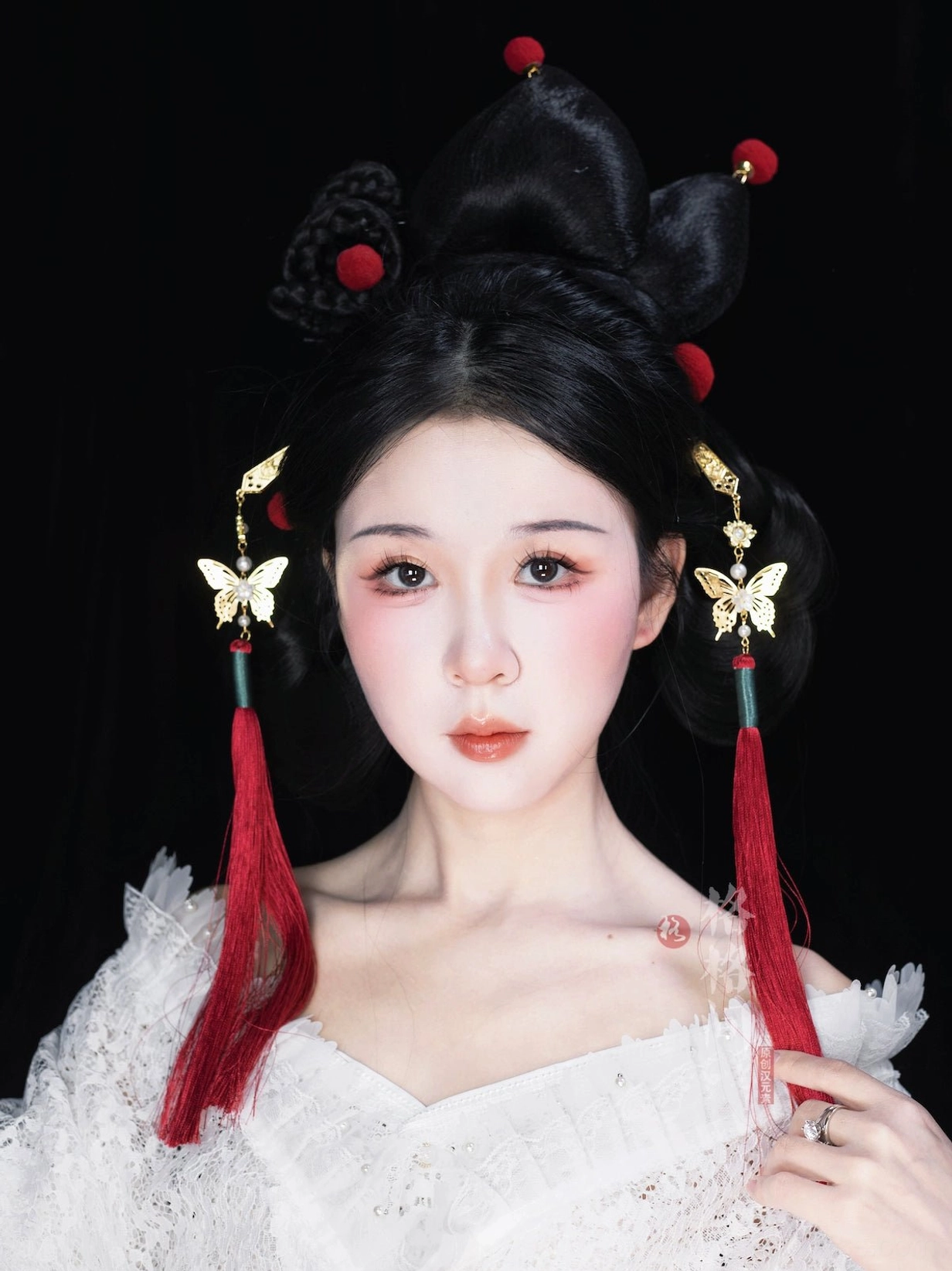 Woman wearing red Chinese butterfly tassel hair pins with gold-tone ornaments in a traditional Hanfu-inspired updo