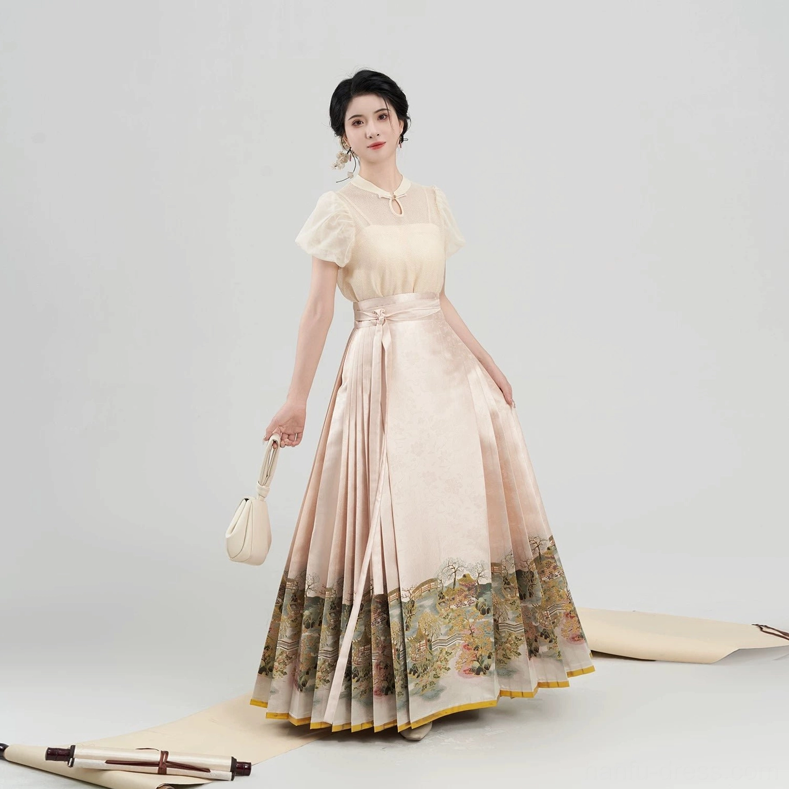 Side view of a coordinated Chinese daily hanfu blouse and mamian skirt outfit in apricot beige with traditional landscape hem and gold edging