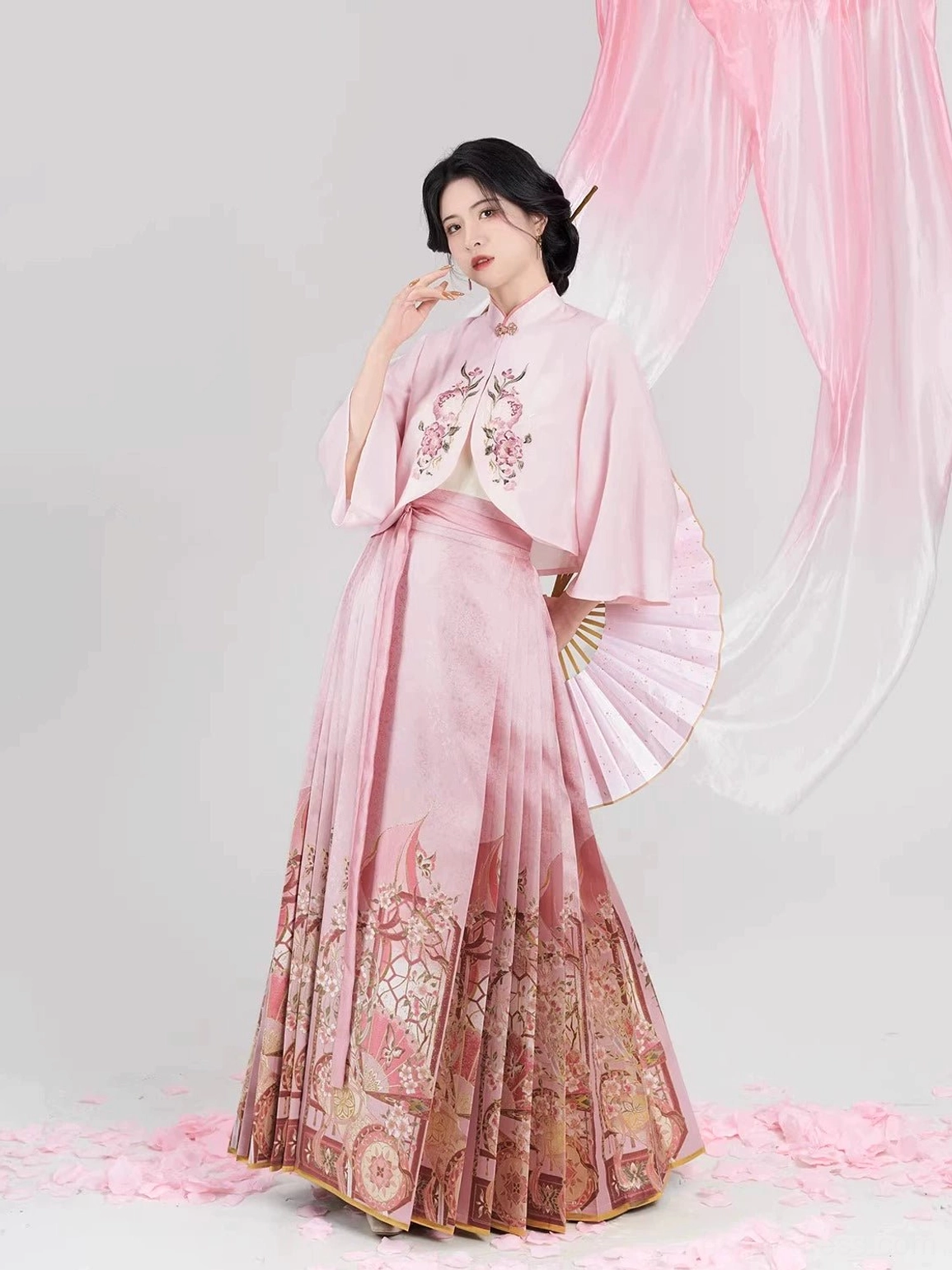 Three-quarter view of a Chinese hanfu blouse and mamian skirt outfit with floral embroidery, vintage printed hem, and folding fan styling