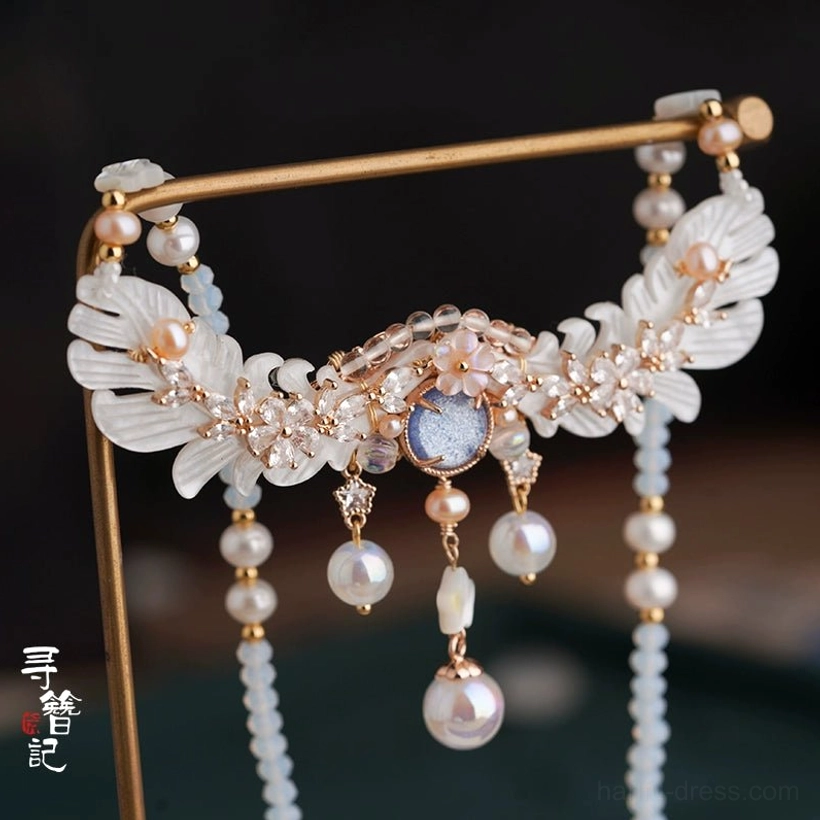 Chinese Hanfu necklet featuring long light blue beaded tassels, white petal-shaped ornaments with gold details, pearl pendants, and a blue-gray central gemstone
