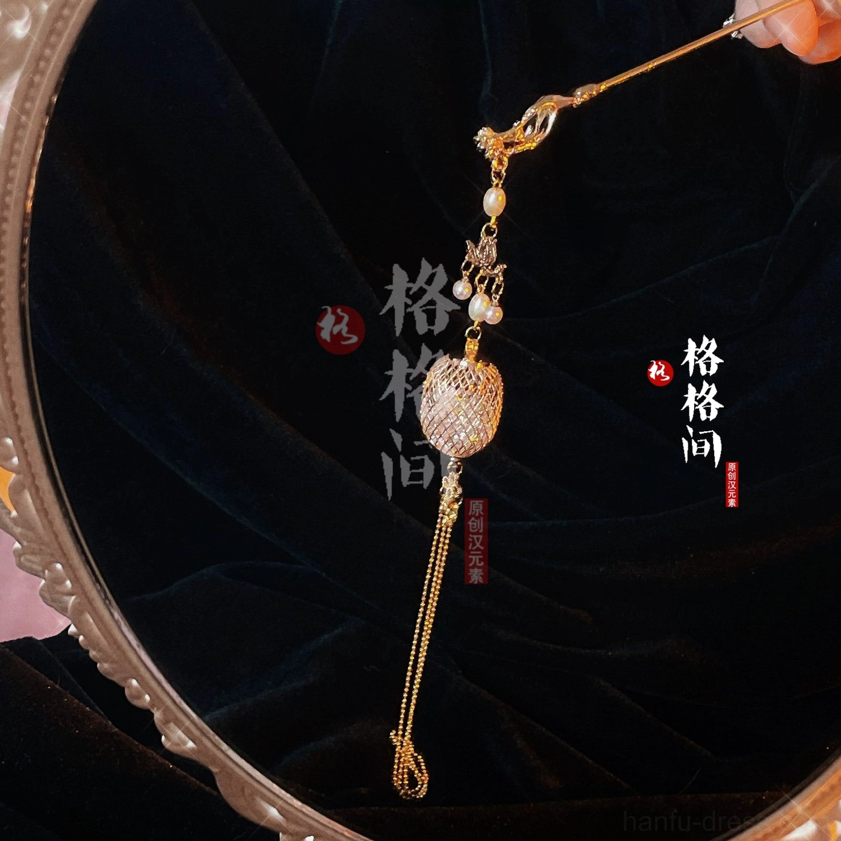 Close up of a Chinese lantern tassel hair pin with gold toned decorative hair stick pearl detail hollow lantern charm and flowing chain tassels