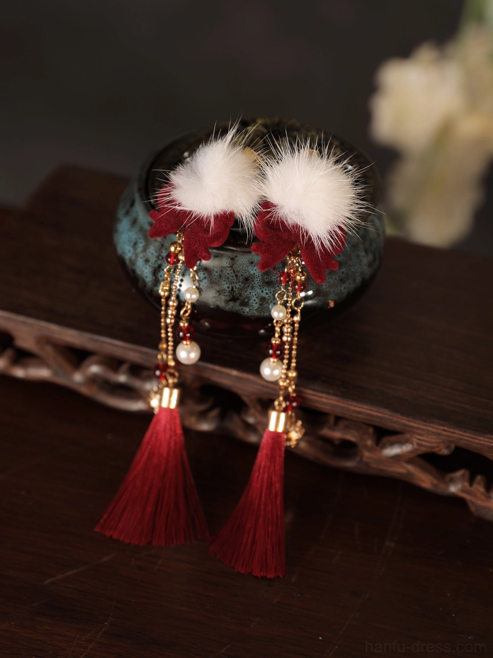 Close-up of red tassel Hanfu hair clips with white plush pom-poms, red flower details, pearl-like beads and gold-tone chains