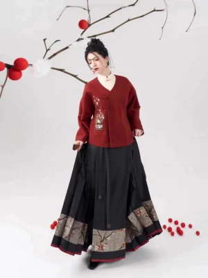 Three-quarter view of a Chinese New Year modern Ming hanfu outfit featuring a deep red flower basket embroidered top and black floral hem mamian skirt