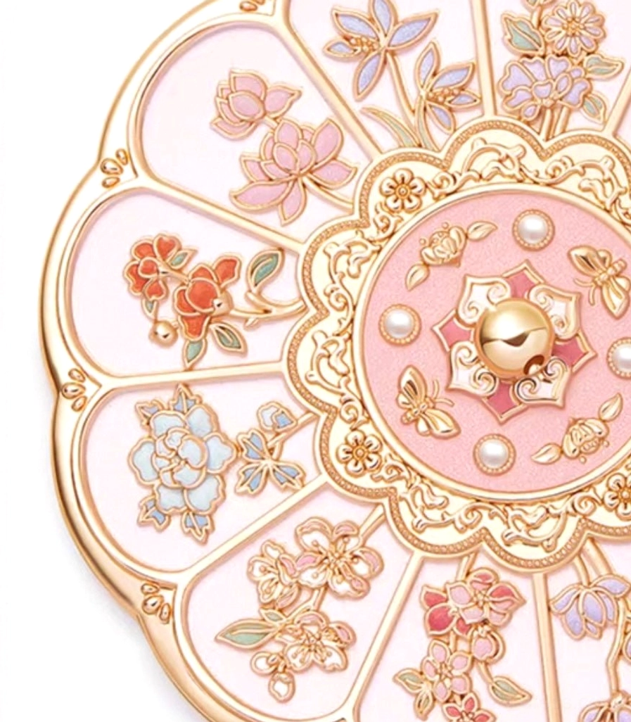 Close-up of colorful enamel-style flowers, gold borders, pearl-like accents, and pink panels on a Chinese pocket mirror cover