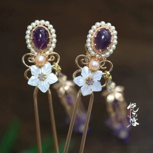 Chinese-style purple gemstone hair pin with pearl accents shell flower ornament and elegant gold tassel displayed against a dark wooden background