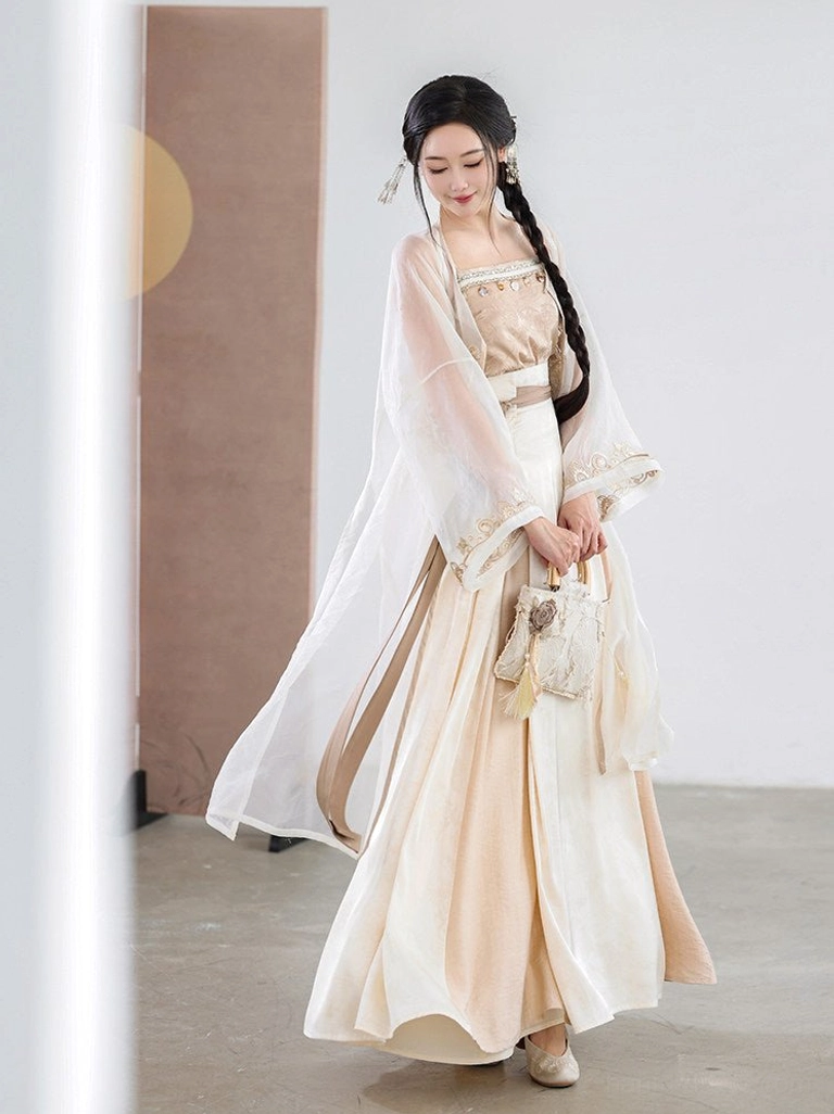 Side view of a cream beige Chinese style Hanfu outfit featuring a two-tone pleated wrap skirt, sheer outer cardigan, and flowing layered silhouette