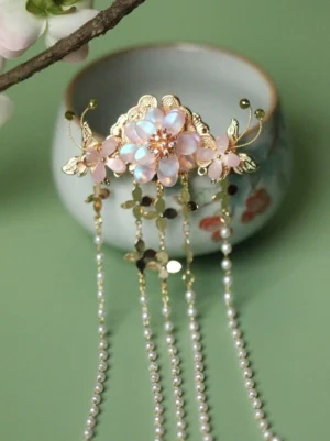 Chinese style floral tassel hair pin featuring a luminous pink flower, gold-tone decorations, layered pearl strands, and shimmering sequin charms