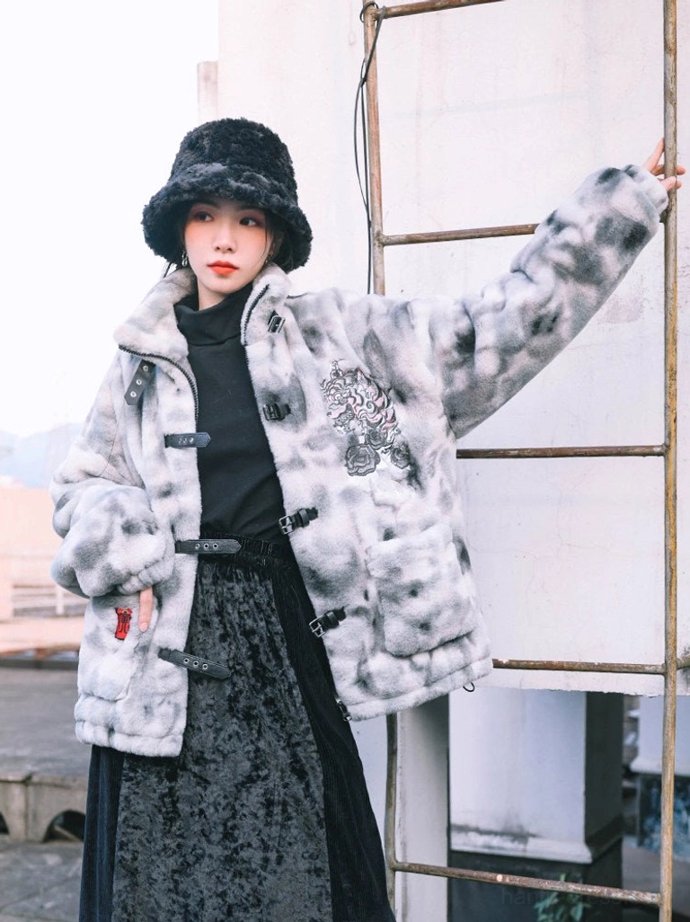 Modern Chinese style faux fur jacket worn with a dark velvet midi skirt, showing the soft plush fabric, stand collar, buckle closure, and embroidered chest design