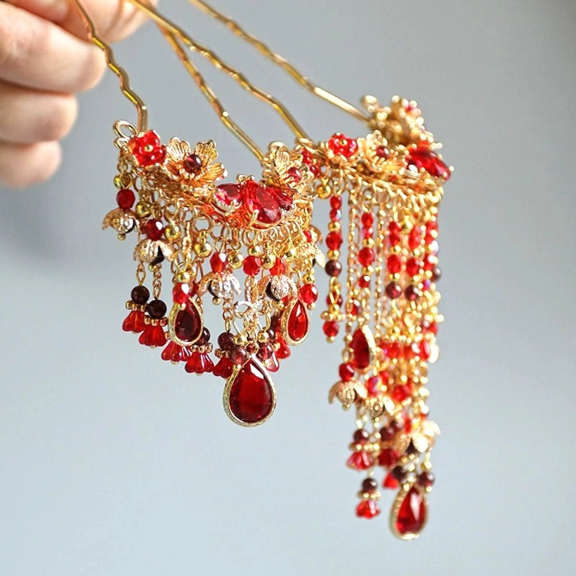 Close-up of traditional Chinese wedding hair pins with gold double-pronged sticks floral ornaments and cascading red bead tassels