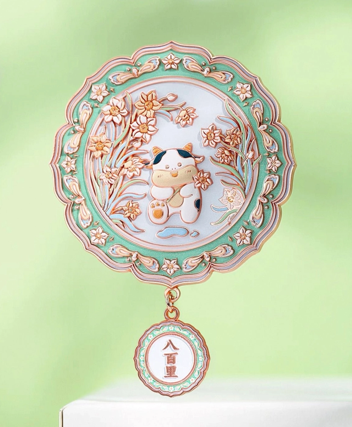 Chinese zodiac ox pocket mirror with green scalloped frame, narcissus floral artwork and auspicious hanging charm