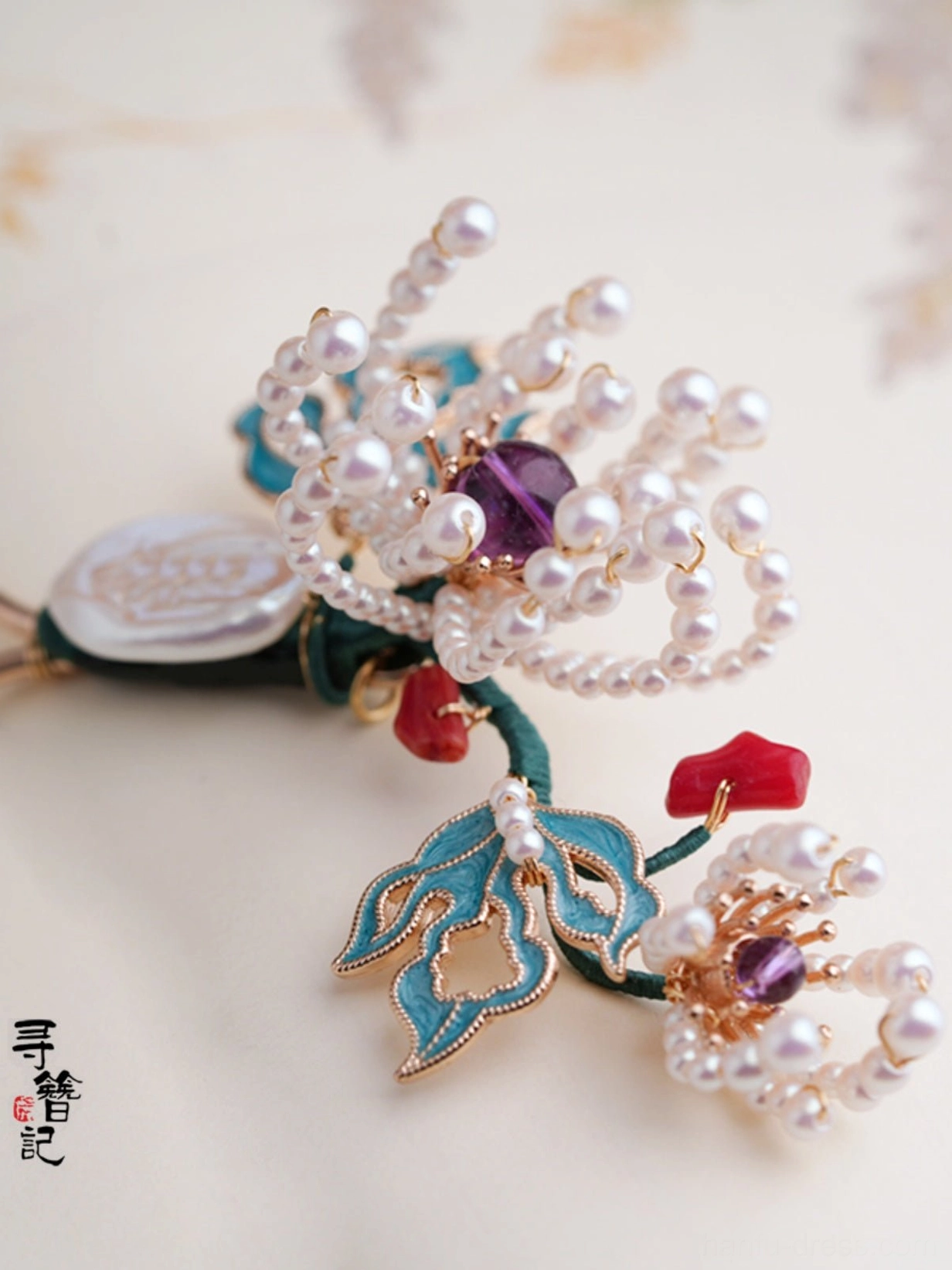 Close up of chrysanthemum Chinese hair fork with pearl flowers blue cloisonne style leaves crystal accents red beads and beaded tassel