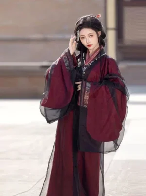 Warring States inspired cinnabar Hanfu robe in red and black with cross collar, sheer-look outer layer, embroidered trim, and decorative waist belt
