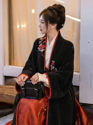 Side view of modern Song Dynasty Hanfu outfit with black embroidered cross-collar jacket, white inner layer, and black leather satchel