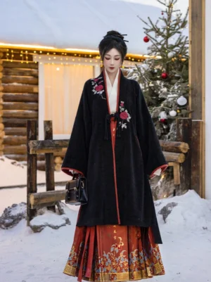 Full front view of black and cinnabar red modern Song Dynasty Hanfu jacket with red mamianqun skirt in a snowy winter setting