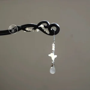 Classic Chinese wooden hair stick with twisted black carved shaft, white decorative beads, and matching silver chain tassel displayed on a neutral background