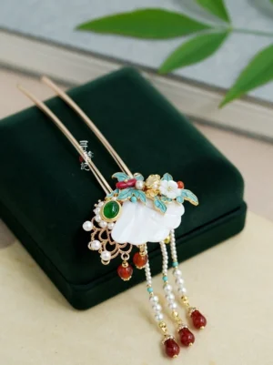 Classical Chinese double-stick Hanfu hairpin displayed on a dark green velvet jewelry box, featuring a fan-shaped shell ornament, cloisonne floral accents, green gemstone, white pearls, red agate beads, and layered tassel pendants