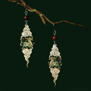 Close up view of Chinese Qilin mythology earrings with auspicious cloud pendants green antique finish red beads and silver earring hooks