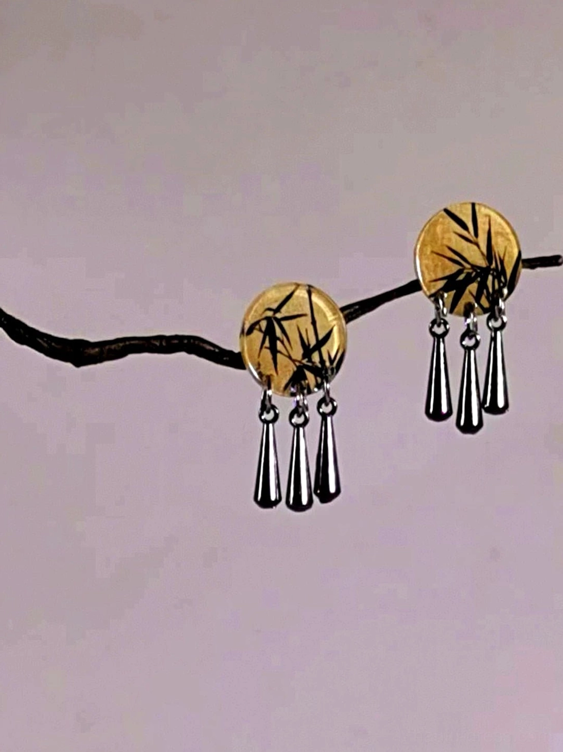 Close-up Chinese bamboo stud dangle earrings with hand-painted black bamboo round charms and three elegant silver teardrop hanging charms