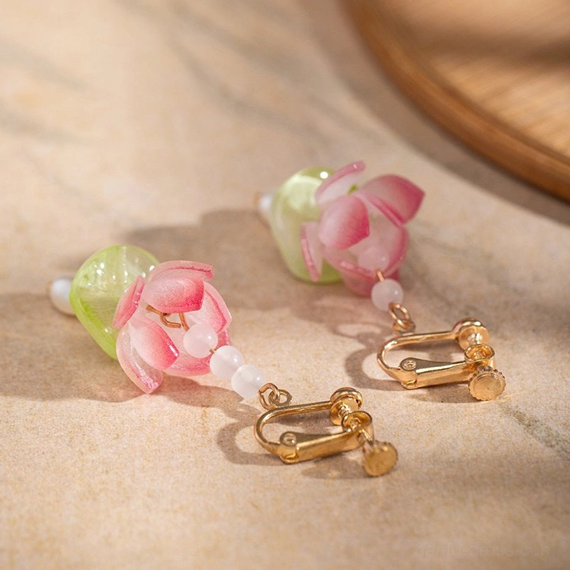 Close-up of clip-on Chinese lotus earrings featuring gold clip clasps, pink flower charms, green decorative beads, and delicate beaded chains