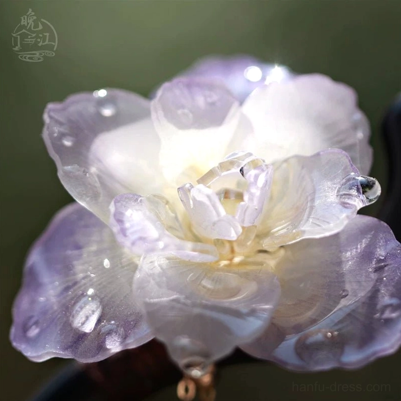 Close-up of layered translucent purple and white resin flower petals with simulated water droplets on a Chinese hair stick ornament