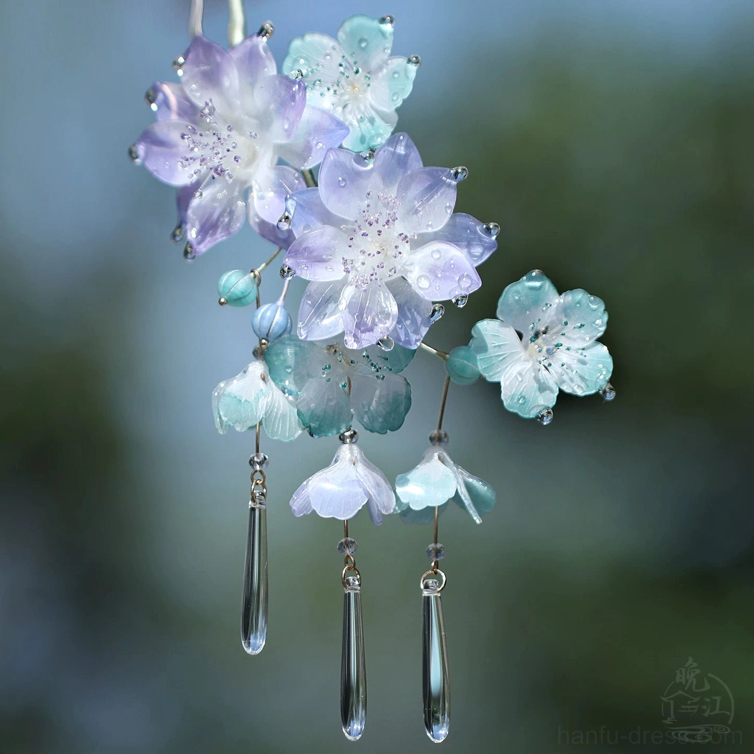 Side view of floral Chinese hair stick featuring violet and cyan blossoms, blue beads, and three clear teardrop tassels