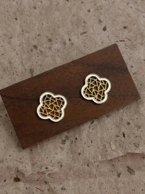 Silver and gold clover lattice stud earrings displayed on a dark wooden board with vintage paper background, Chinese Cheongsam jewelry flat lay