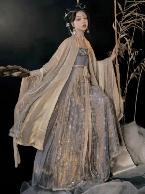 Cold Tangerine Tang Dynasty Hanfu Heziqun dress in apricot beige and lilac with wide sheer sleeves, shimmering skirt, embroidered bust trim, and matching sash on a vintage rope swing