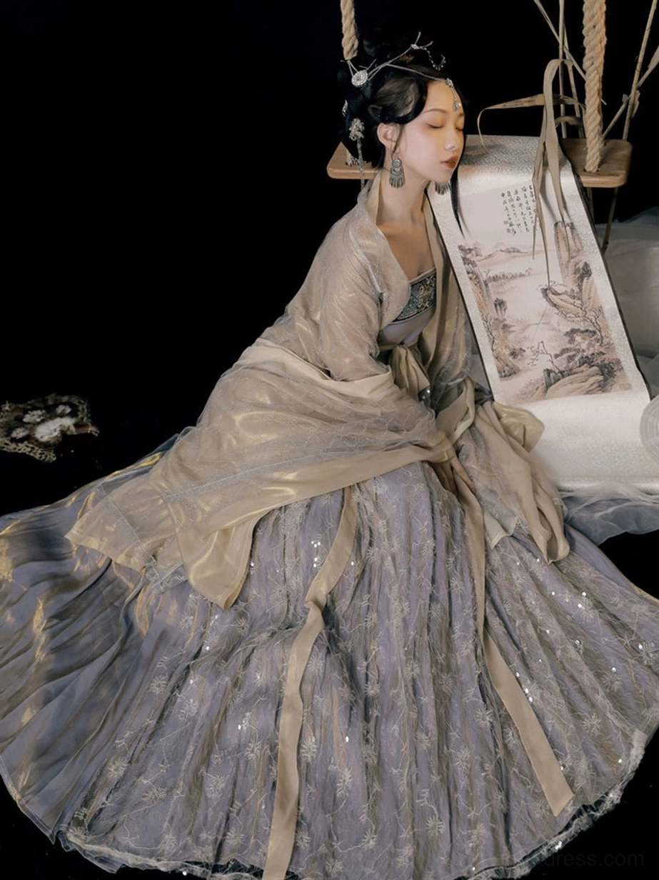 Side sitting view of a Cold Tangerine Tang Dynasty Hanfu dress with coordinated beige and lilac layers, flowing skirt train, and elegant traditional silhouette