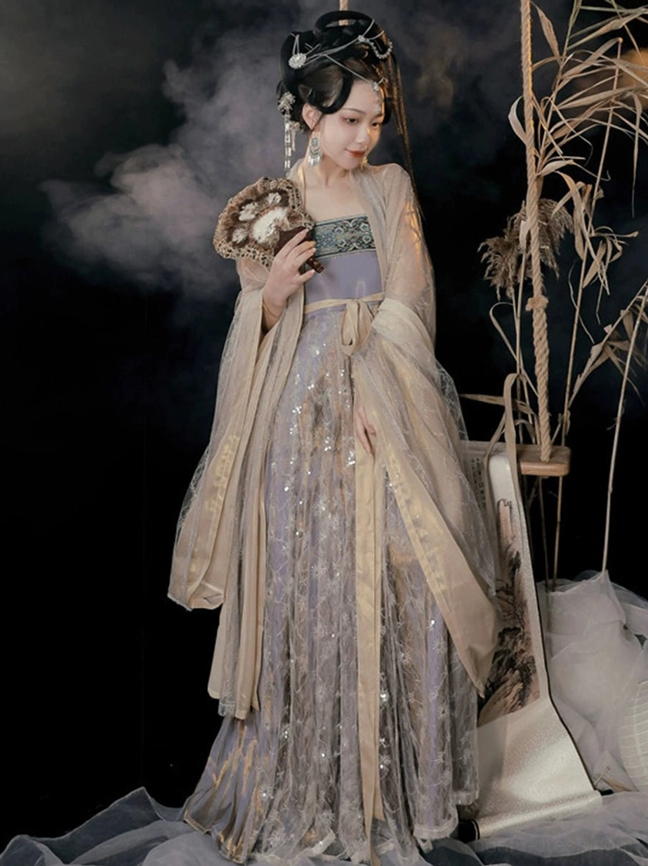 Three-quarter view of Cold Tangerine Tang Dynasty Hanfu Heziqun set with embroidered bust decoration, metallic lilac skirt, apricot coat, and matching waist sash