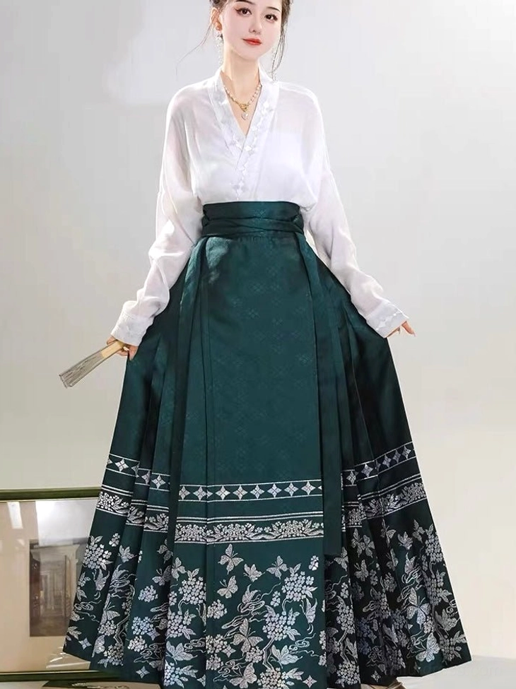 Complete modern Hanfu outfit featuring a white cross-collar top and dark green high-waisted mamianqun skirt with floral and butterfly embroidery