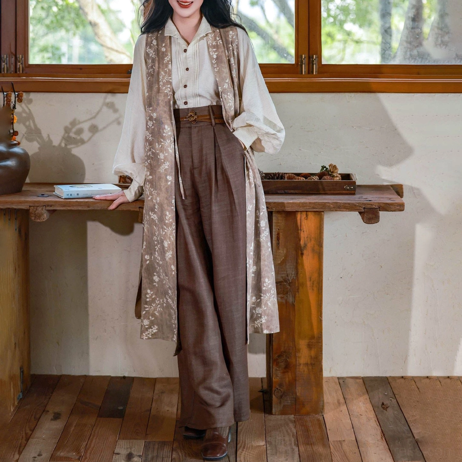 Complete modern Ming Dynasty inspired hanfu set with off-white top, long floral robe, and dark brown wide leg pants in a vintage studio
