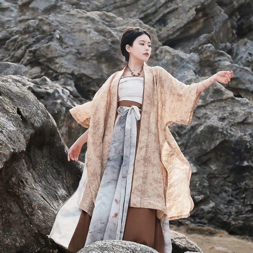 Full-length outdoor side view of a woman wearing the complete modern summer Hanfu set with a flowing loose silhouette and earthy ink-wash colors