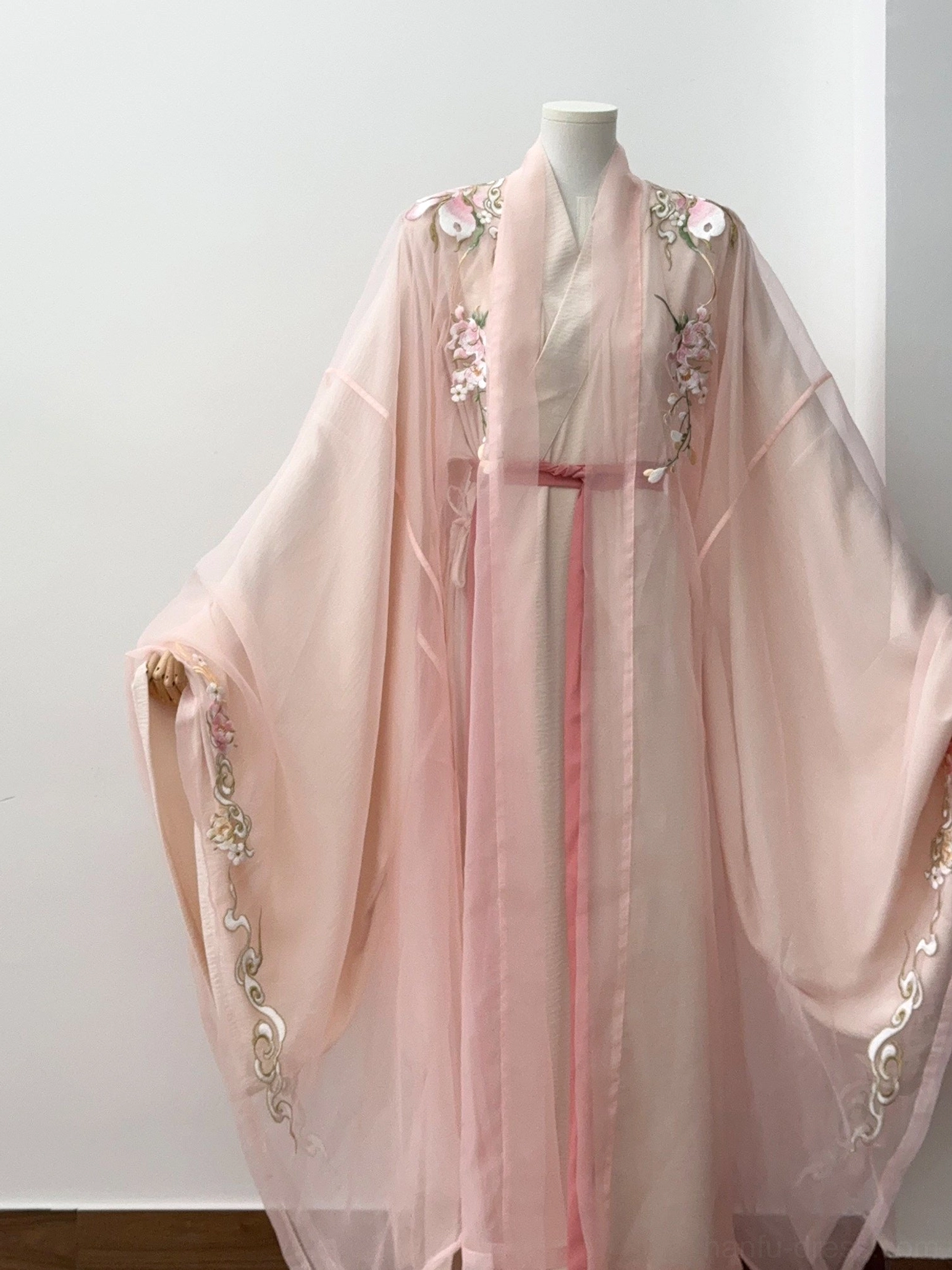 Complete pink embroidered Chinese hanfu set displayed on a dress form, showing cross-collar robe, floral front embroidery, sleeve cuffs, sheer layers, and matching waist sash