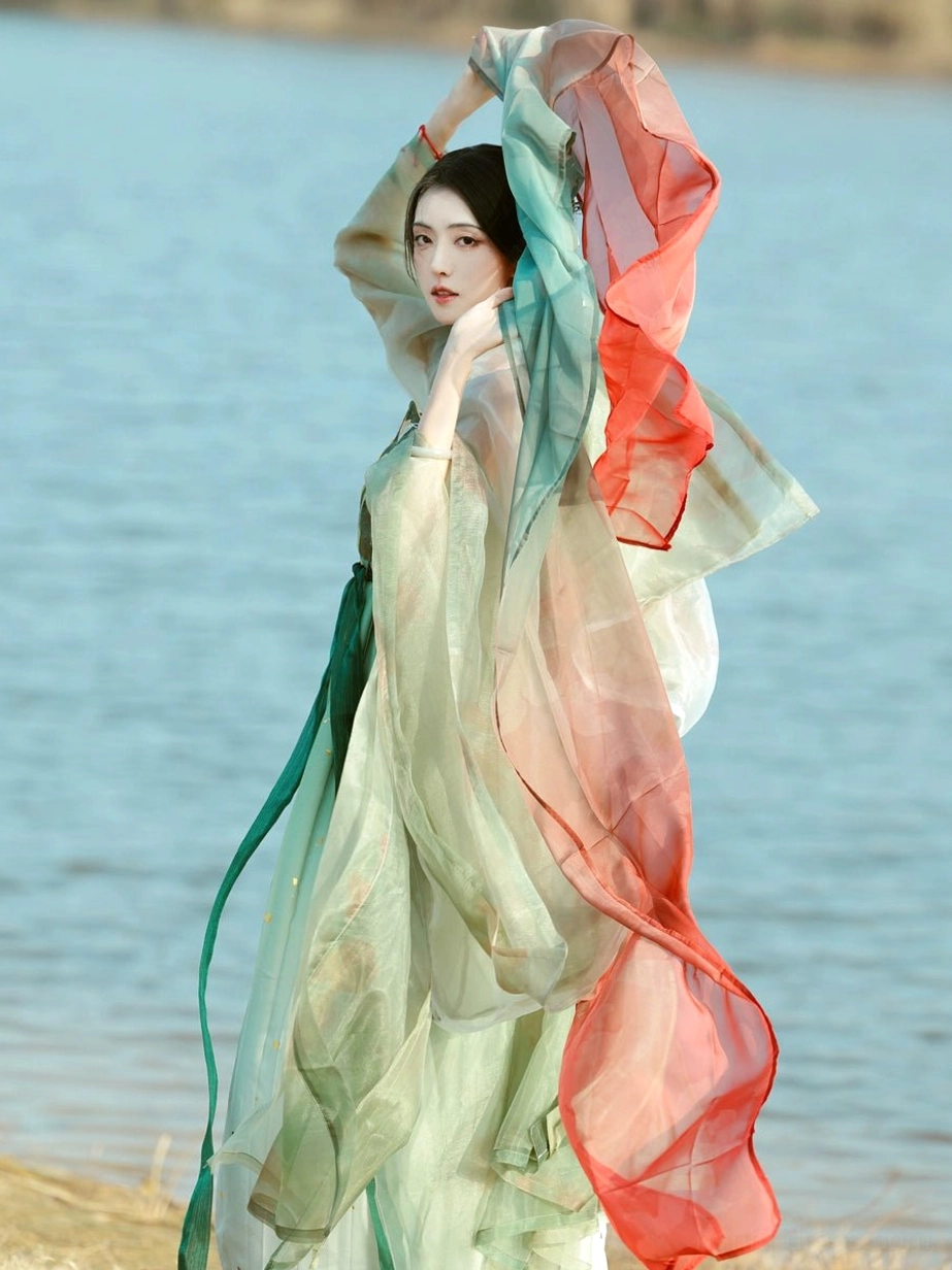 Complete Tang Dynasty Hanfu Heziqun set viewed from the side and back, featuring a flowing pale green skirt, sheer outer coat, waist sash, and layered traditional silhouette