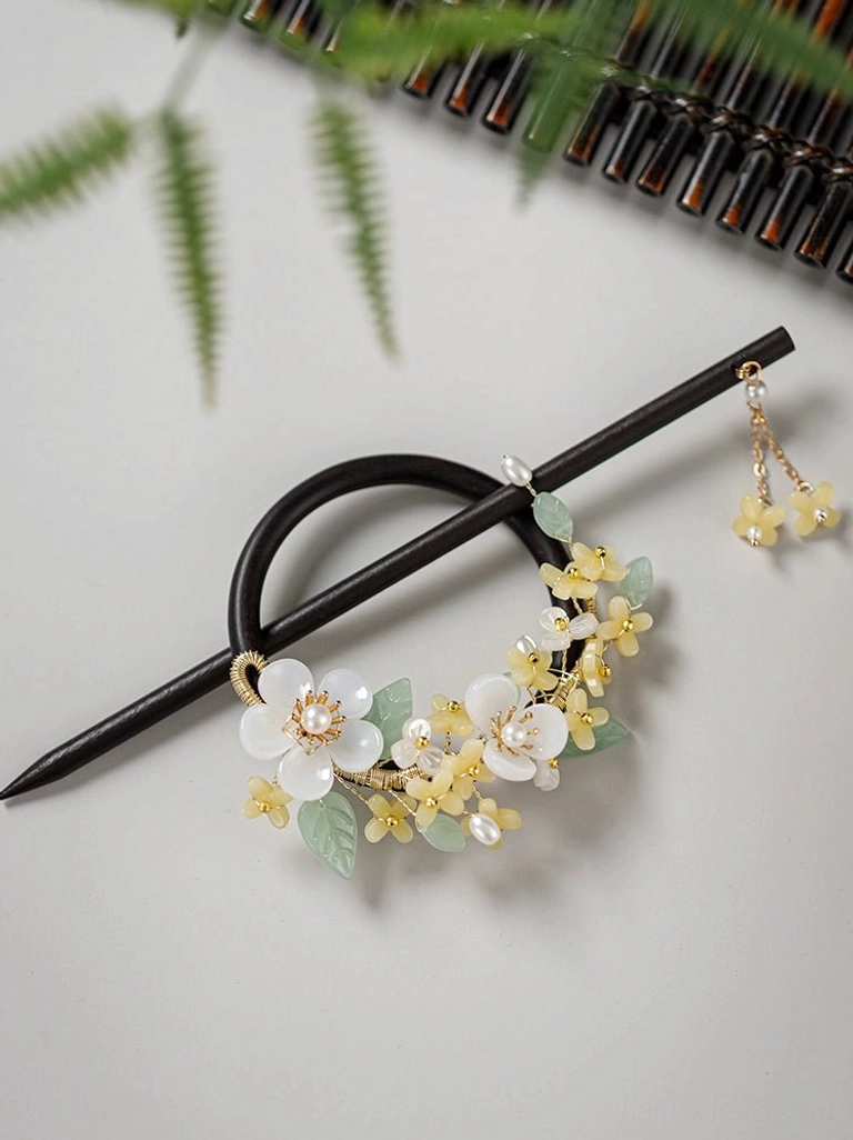 Flat lay of a complete Chinese wooden hair pin set with floral ornaments pearl accents and detachable tassel