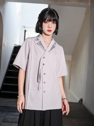 Contemporary Chinese style Hanfu shirt with asymmetric button placket, vertical darts, matte woven fabric, and embroidered lapels shown on model
