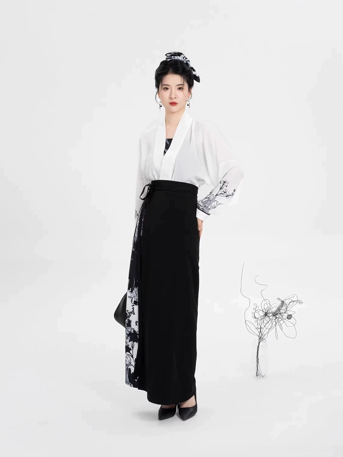 Front view of contemporary Song Dynasty Hanfu with high-waisted long wrap skirt, ink floral side print, winged sleeve top, and traditional hair ornament