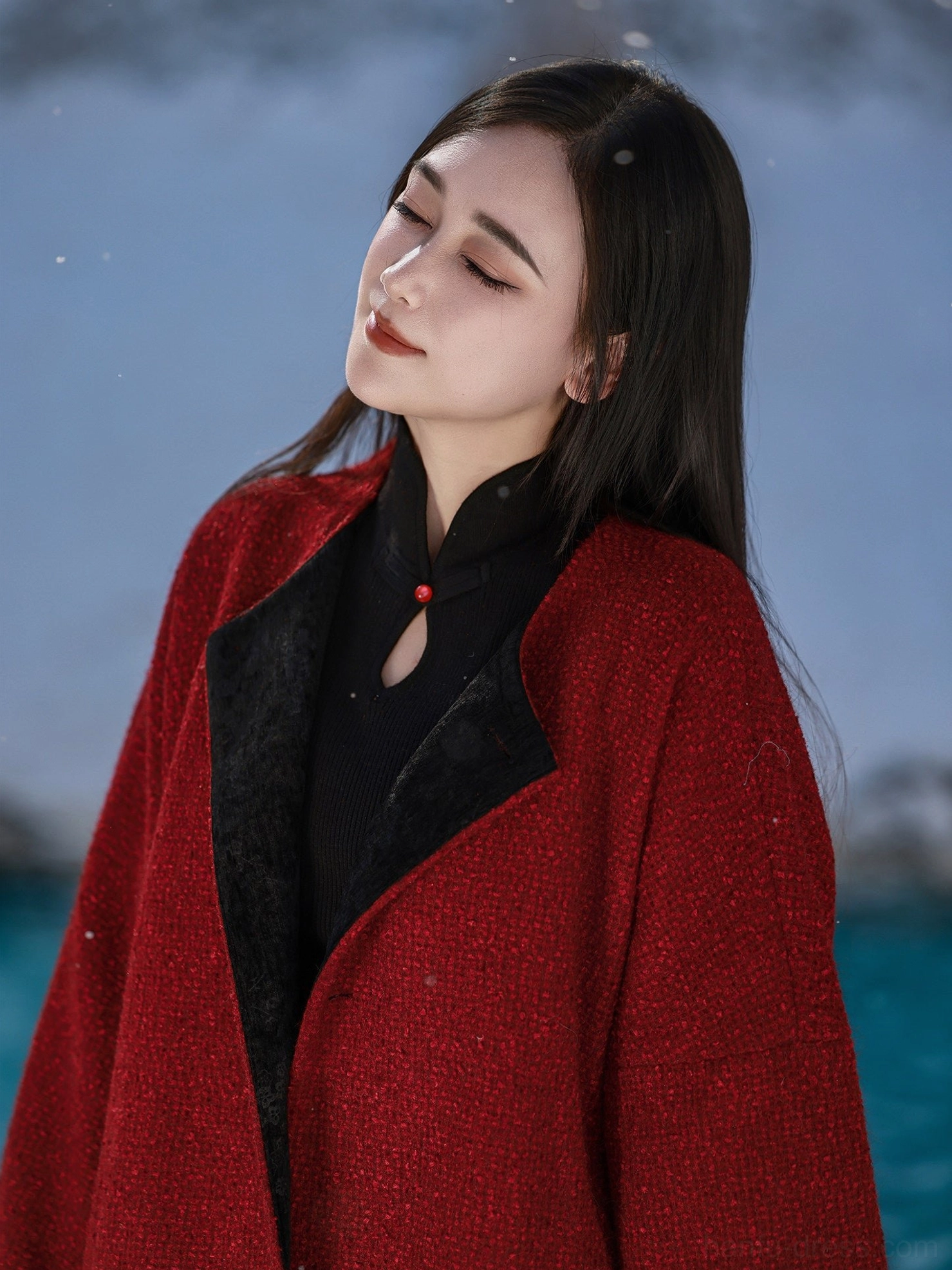 Close-up detail of coral red textured hanfu jacket with traditional stand collar keyhole neckline red bead and black fuzzy lapel