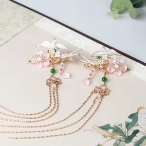 Pair of matching crane Hanfu side hairpins with pink cherry blossoms, green beads, pink pendants, and long gold tone chain tassels