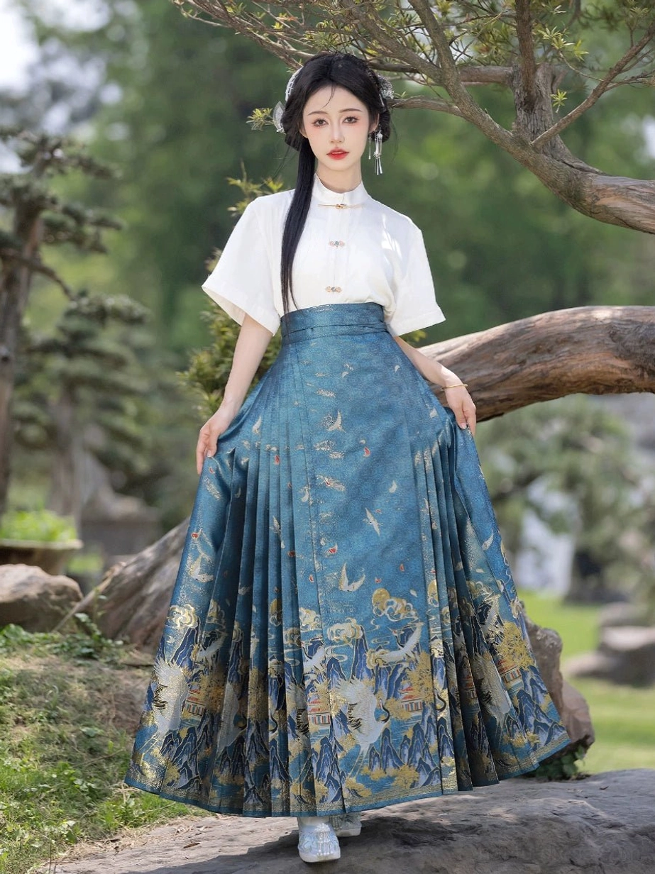Blue Ming Dynasty inspired mamianqun horse face skirt with crane mountain and cloud motifs styled with a white Hanfu blouse