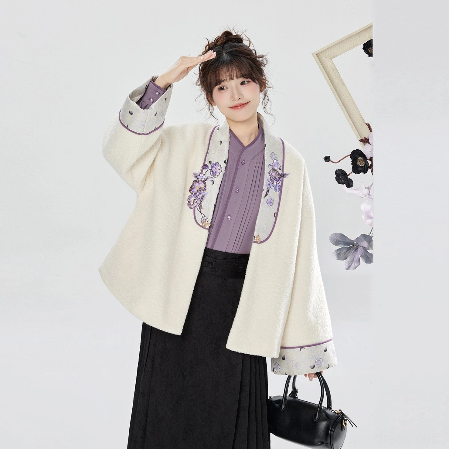Detail view of a cream embroidered Ming-inspired hanfu jacket layered over a matching lavender shirt with coordinated floral decoration