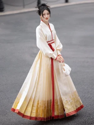 Front view of a model wearing a cream Ming Dynasty Hanfu mamianqun skirt with pleats, metallic floral hem, red trim, white cross-collar top, and red waist sash