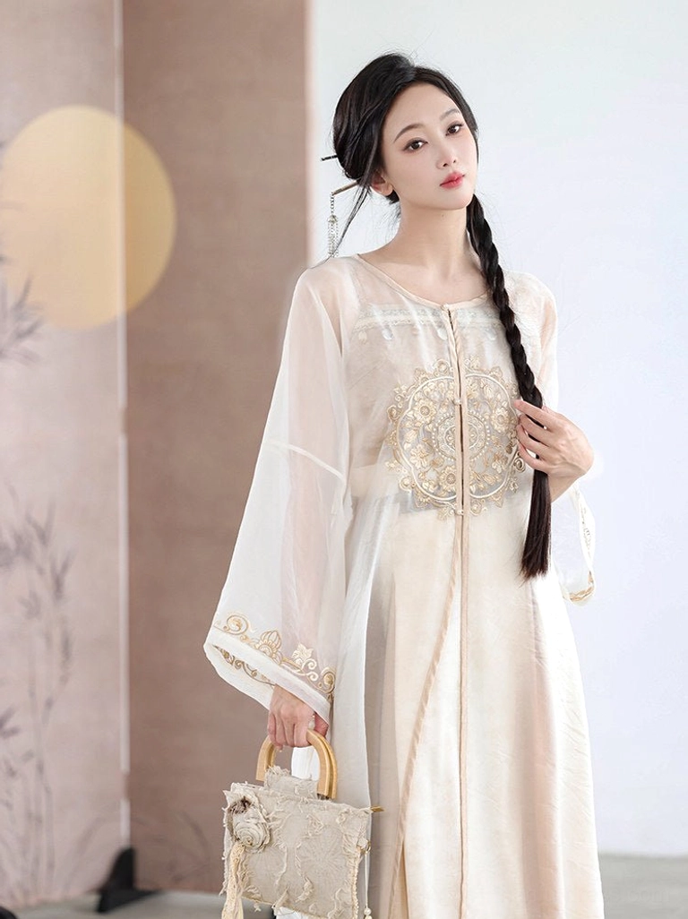 Close front view of a cream white sheer Hanfu fairy cardigan with circular floral embroidery, long sleeves, and contrasting cuff trim