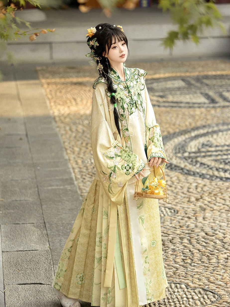 Cream yellow Ming Dynasty Hanfu set with floral embroidered cloud collar and mamian skirt shown from a three-quarter back view on a Chinese garden path