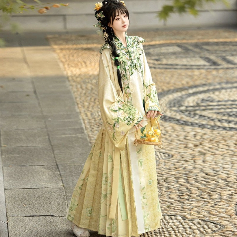 Cream yellow Ming Dynasty Hanfu full set with intricate floral cloud collar embroidery, pipa sleeve top and printed mamian skirt on garden pathway